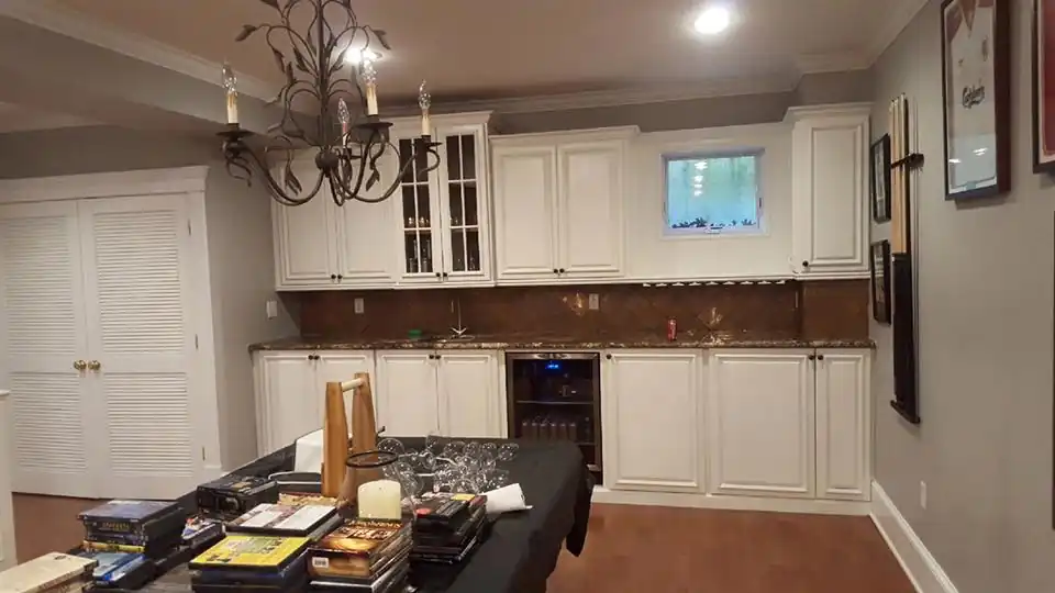 Kitchen wall of white cabinets with glass-front uppers above a dark counter