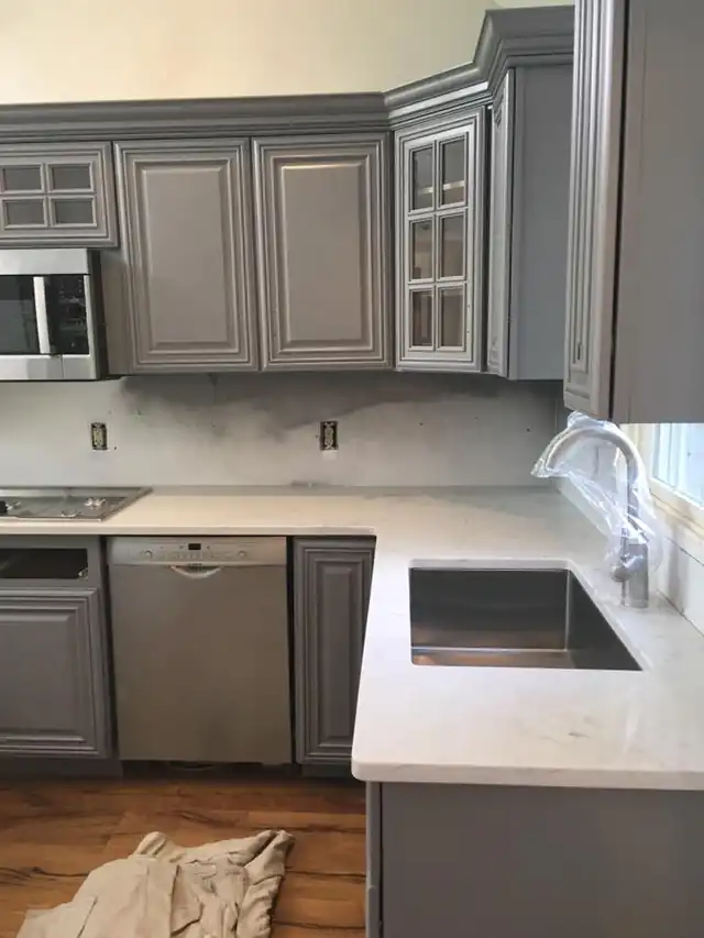 Refinished gray kitchen cabinets with white counters