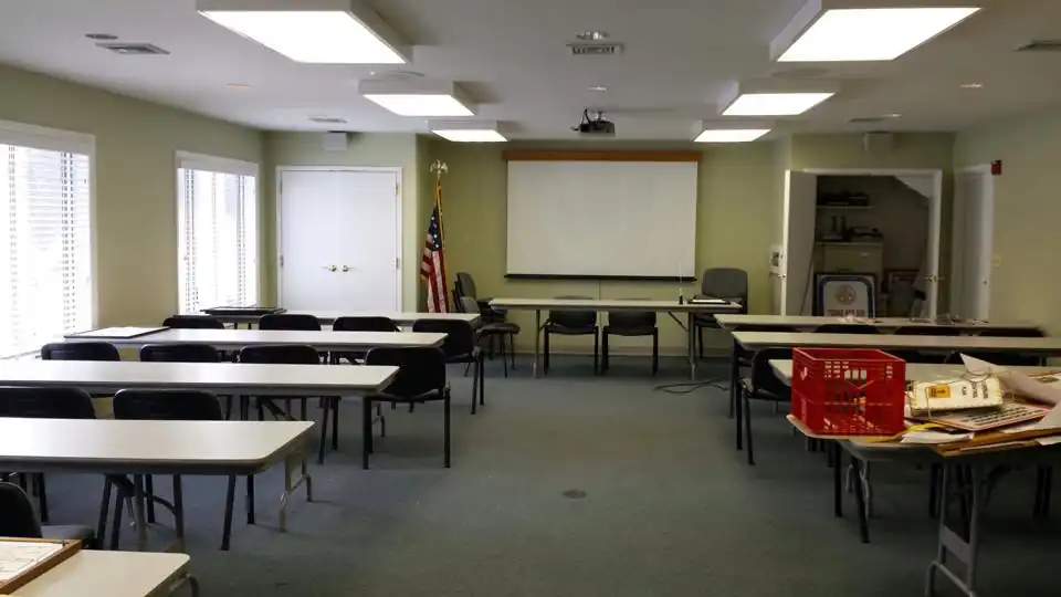 Commercial training room with freshly painted two-tone walls and rows of tables