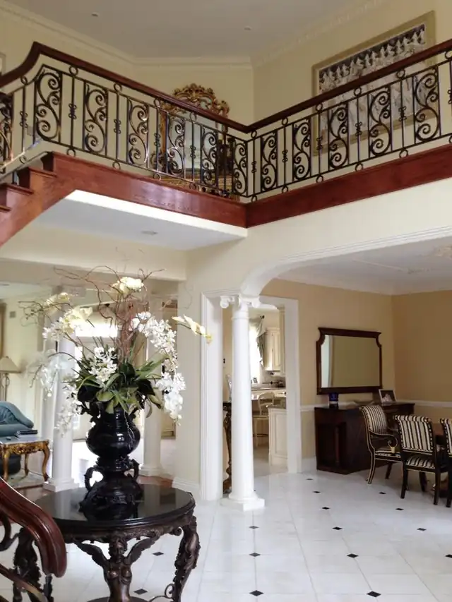 Two-storey foyer with an iron balcony rail and columns
