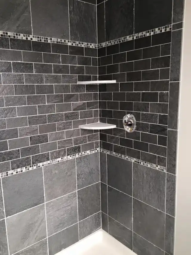 Dark shower with a mosaic tile band