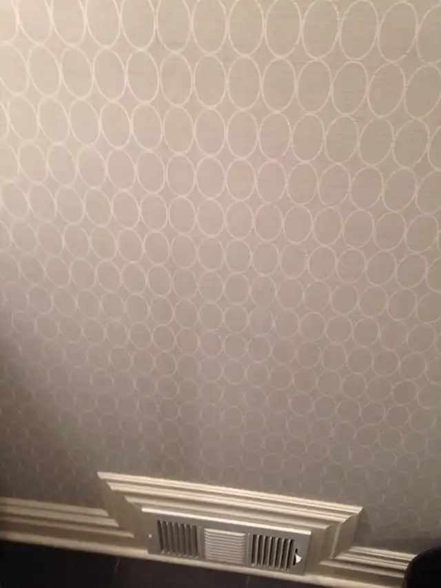 Patterned wallpaper meeting a white chair rail